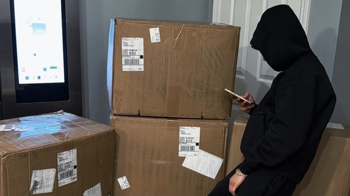 Reseller in a black hoodie beside stacked shipping boxes; no physical products included